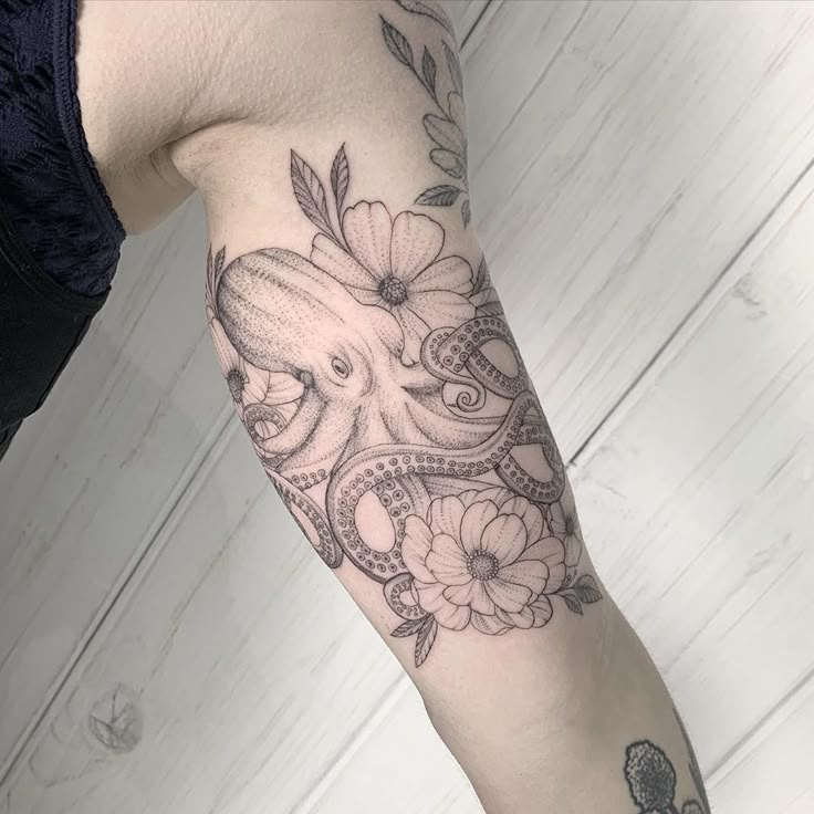 an octopus and flowers tattoo on the arm