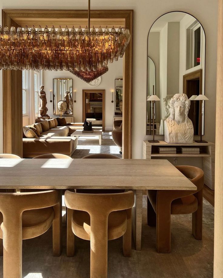 a dining room table with chairs and a chandelier hanging from it's ceiling