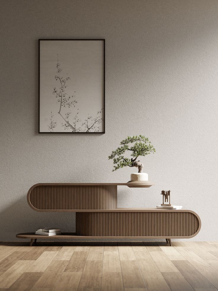 a plant is sitting on top of a wooden table in front of a framed art piece