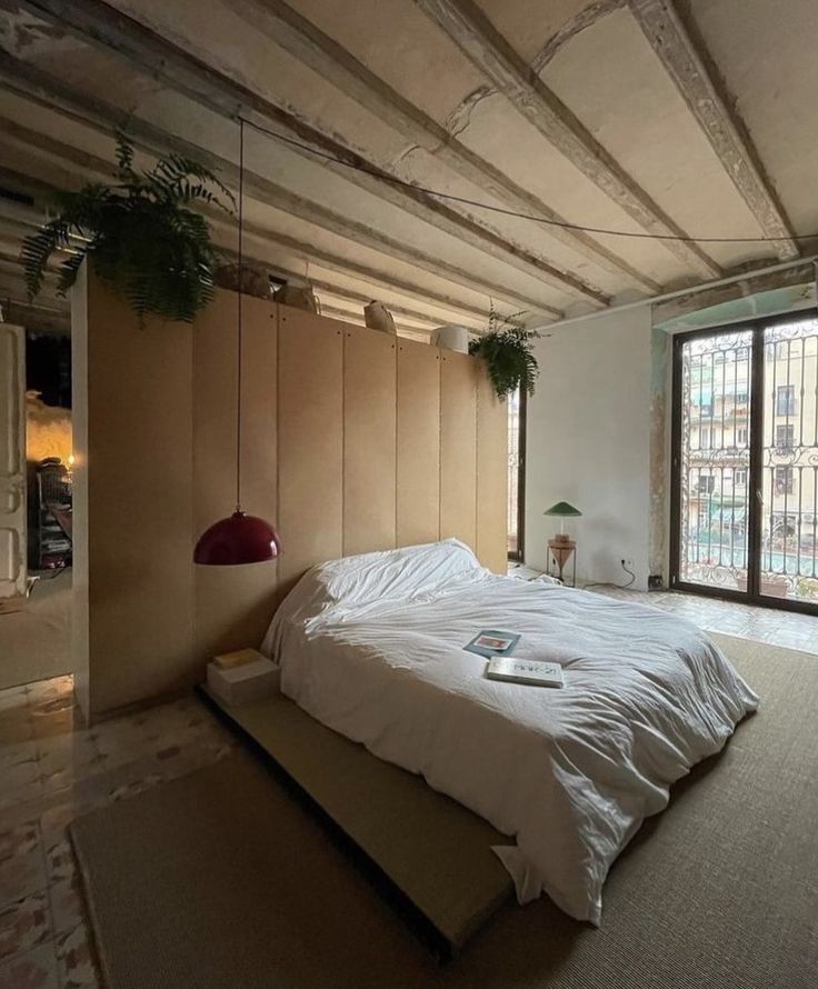 a bed sitting in the middle of a room next to a window