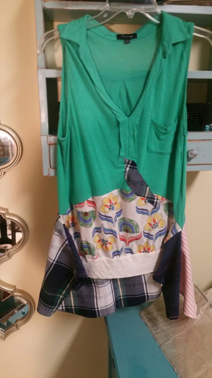 a green shirt is hanging on a rack in front of a blue cabinet and mirror