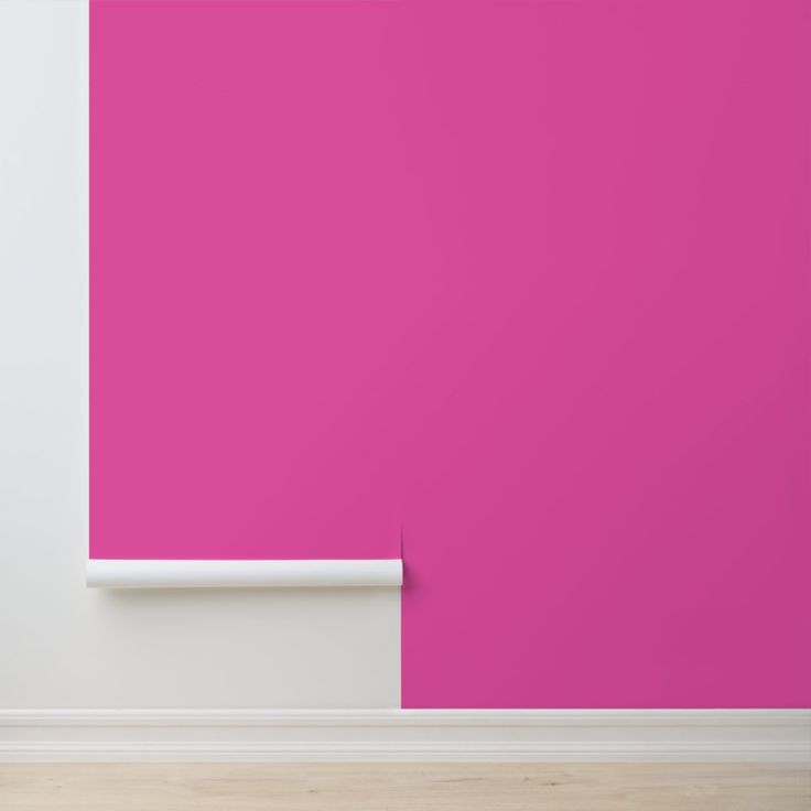 an empty room with a pink wall and white trim on the walls, in front of a wooden floor