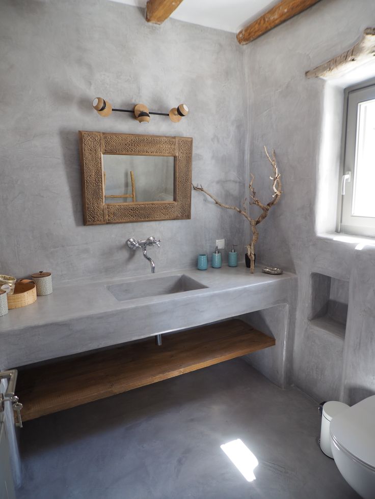 a bathroom with a sink, mirror and toilet in it's center piece is shown