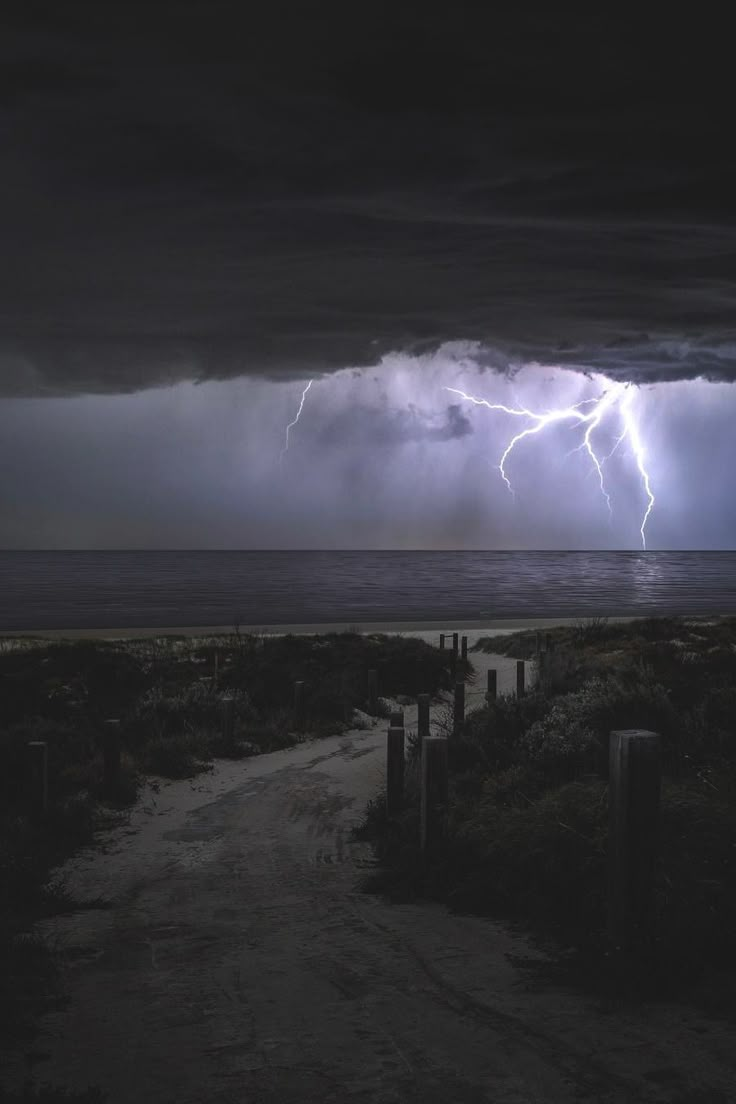 a lightning storm is coming over the ocean