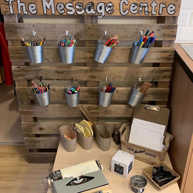 the message centre is set up with several buckets and pencils on it, along with other stationery items