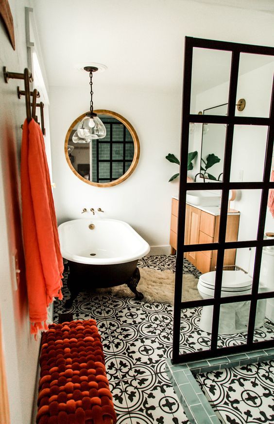 a bath room with a toilet and a bath tub next to a mirror on the wall