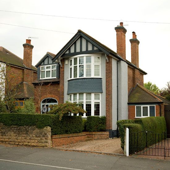 a large house with many windows on the side of it's roof and fenced in area