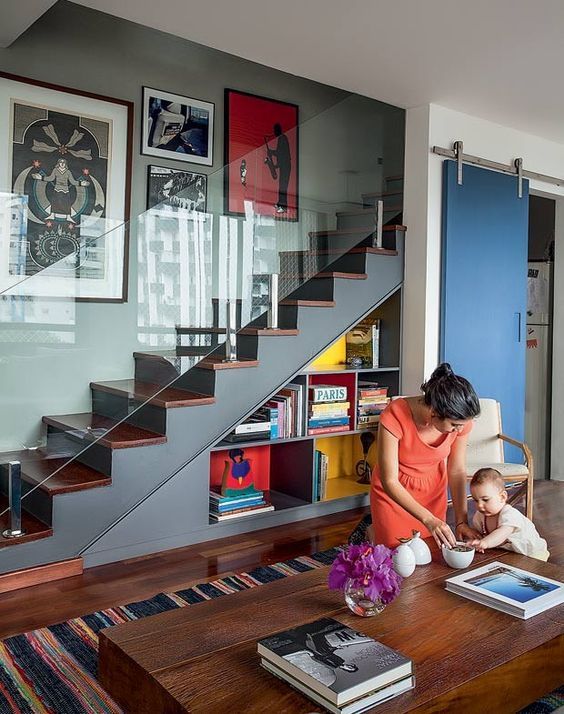 an image of a woman reading to her toddler on the floor in front of stairs