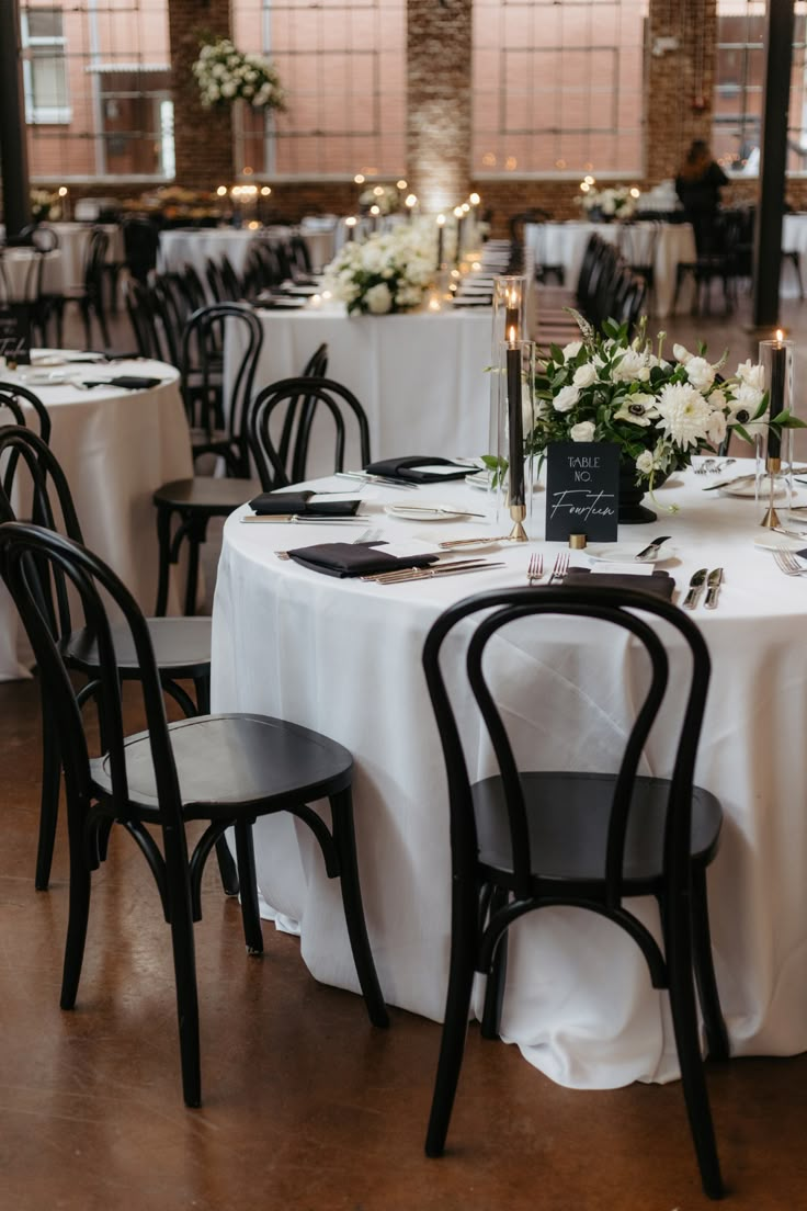 the tables are set with white and black linens for an elegant wedding reception,