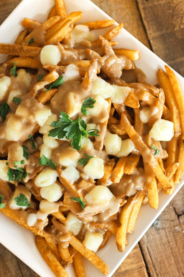 french fries covered in gravy and garnished with parsley