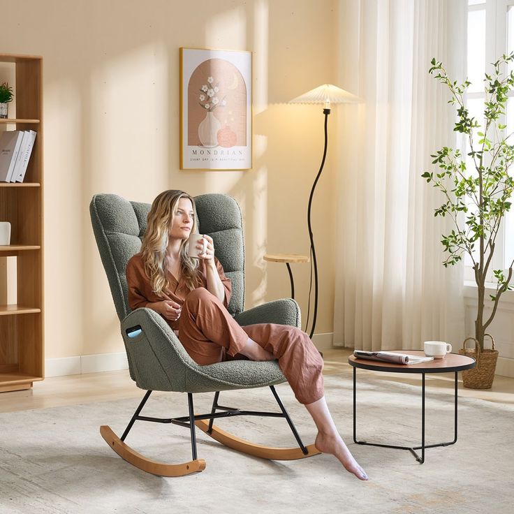 a woman sitting in a rocking chair holding a cup