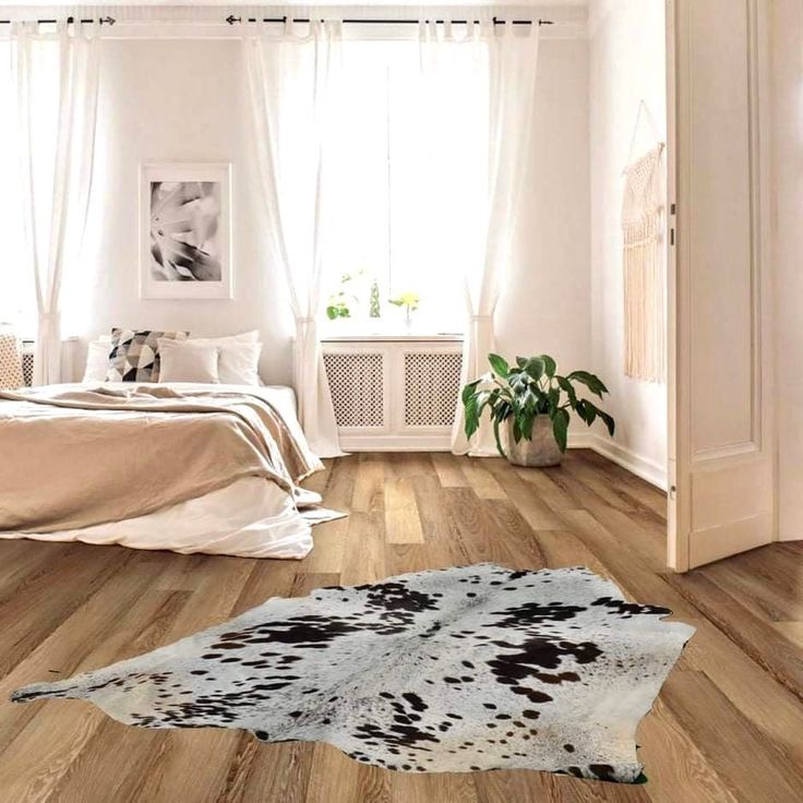 a bedroom with wood floors and white walls