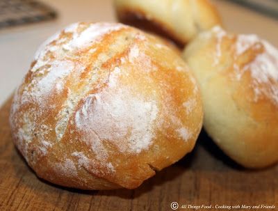 three loaves of bread sitting on top of a wooden cutting board next to a computer keyboard