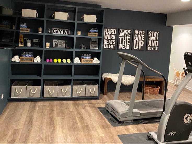 a gym with treads, exercise equipment and storage shelves on the wall behind it