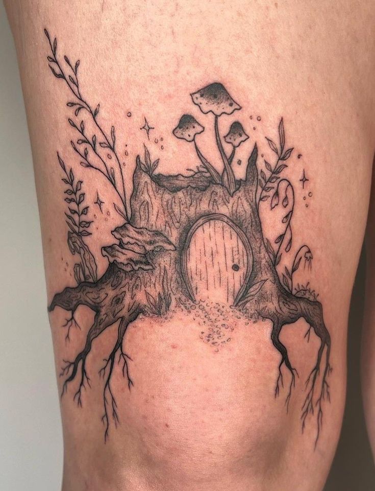 a woman's thigh with an image of a tree stump and mushrooms on it