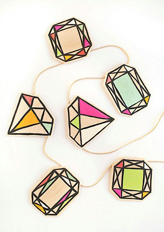 six different colored geometric shapes are arranged on a white surface, including one in the shape of a diamond