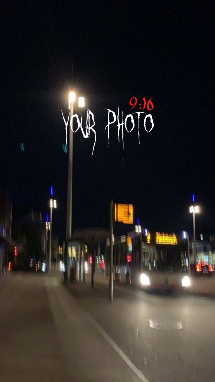 the word your photo is written on top of a street sign in front of a city at night