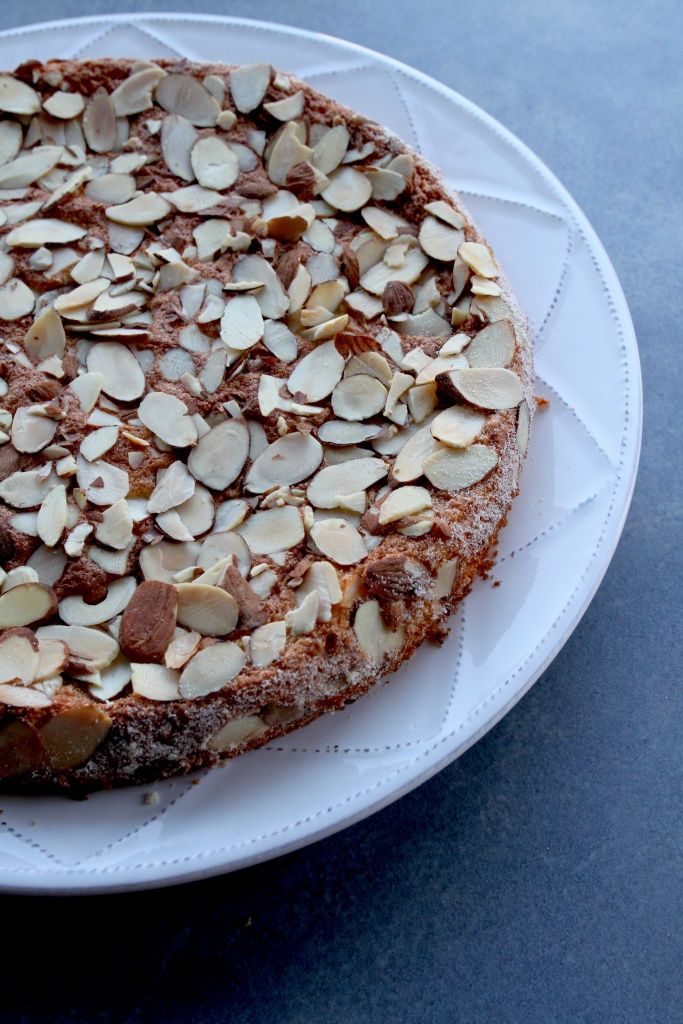 a white plate topped with a cake covered in almonds