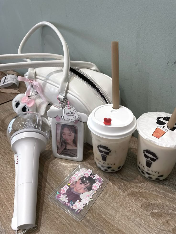 an assortment of items on a table including two cups, a hair dryer and a cell phone