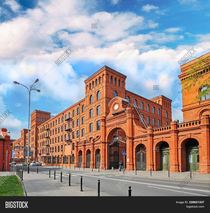 an old red brick building on the corner of a street in front of tall buildings