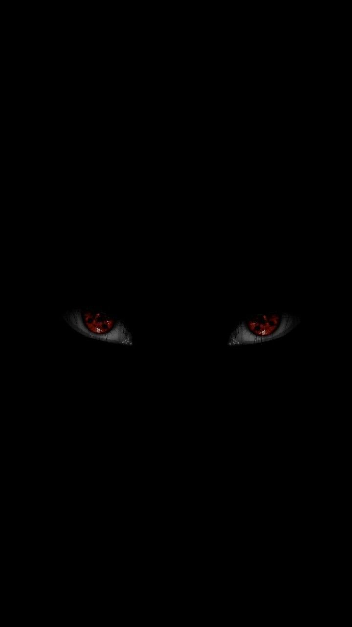 red eyes are glowing in the dark, with only one eye visible to the left