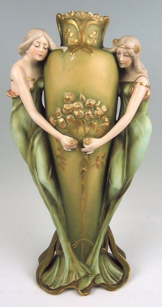 a vase with two women holding flowers on it