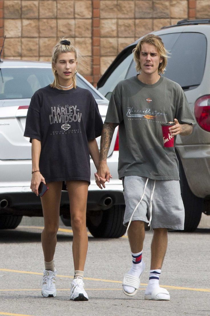 a man and woman are walking down the street holding hands with each other while wearing matching t - shirts