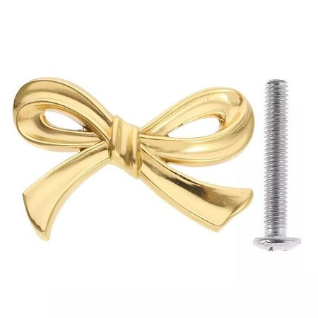 a gold plated metal bow tie on a white background with a screw in the foreground