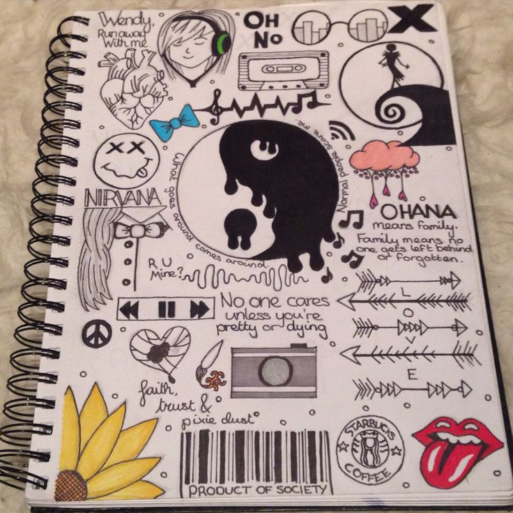 a spiral notebook with various stickers and symbols on the pages, including an image of a woman's face