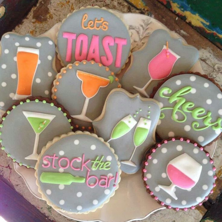 some decorated cookies are sitting on a plate with the words, let's toast and stock the bar