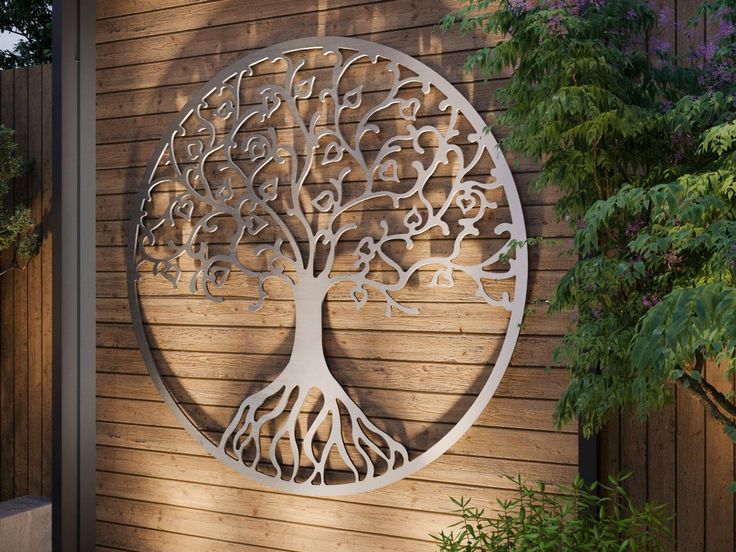 a metal tree is mounted to the side of a wooden wall in front of a house