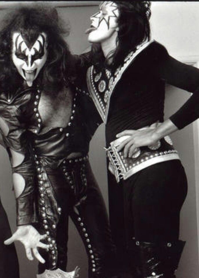 two men dressed as kiss band members posing for the camera with their mouths wide open