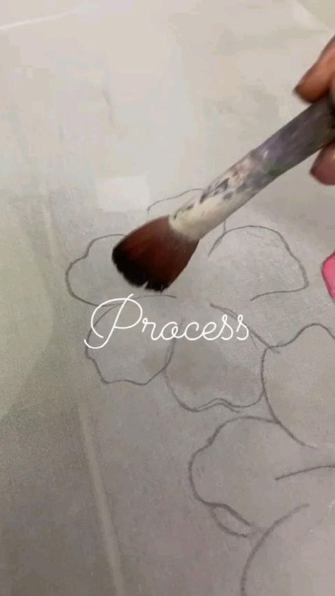 someone is using a paintbrush to draw flowers on the paper with white writing that says process