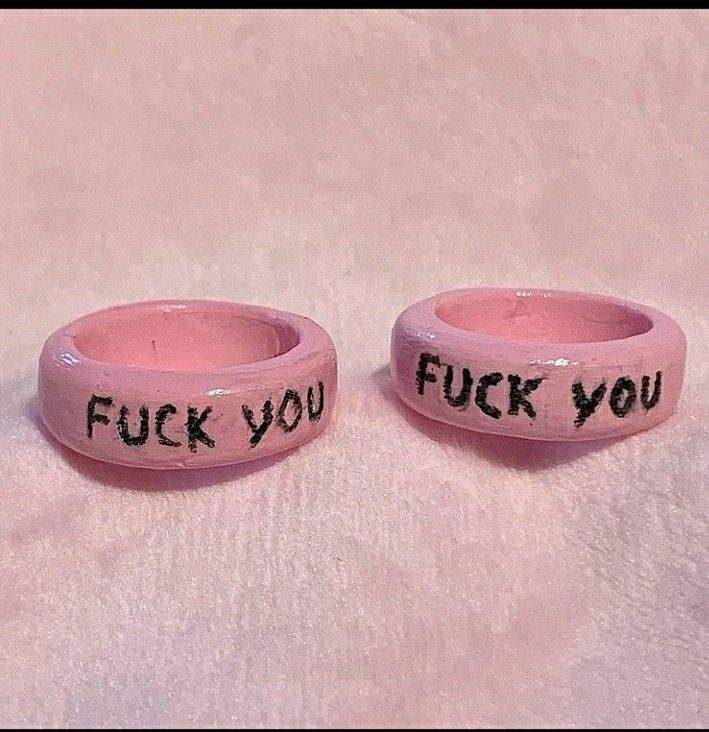 two pink bracelets with words written on them