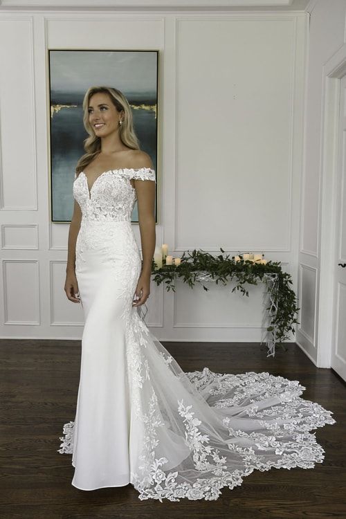 a woman in a white wedding dress standing on a wooden floor next to a painting