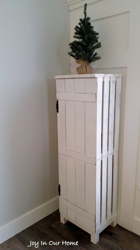 a white cabinet with a potted plant on top