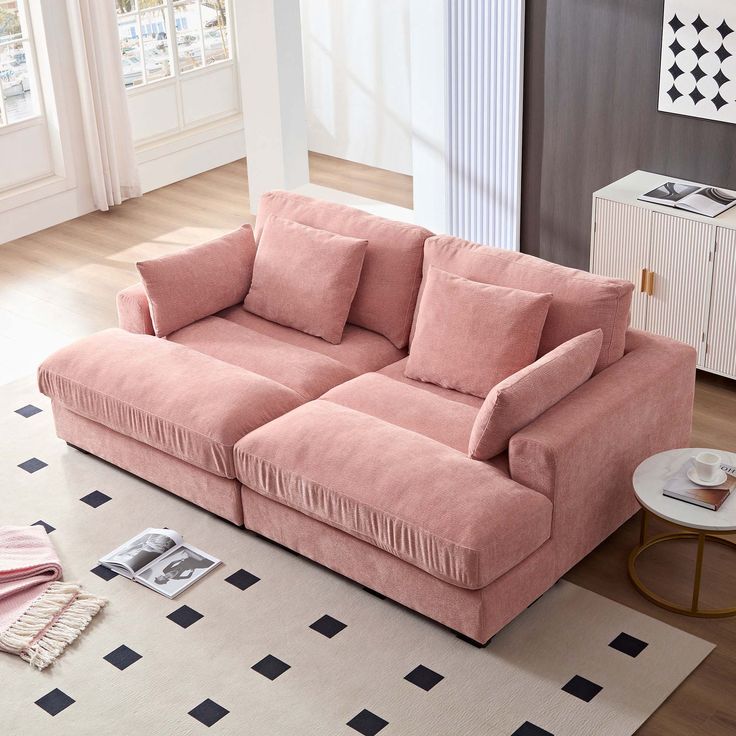 a pink couch sitting on top of a white rug