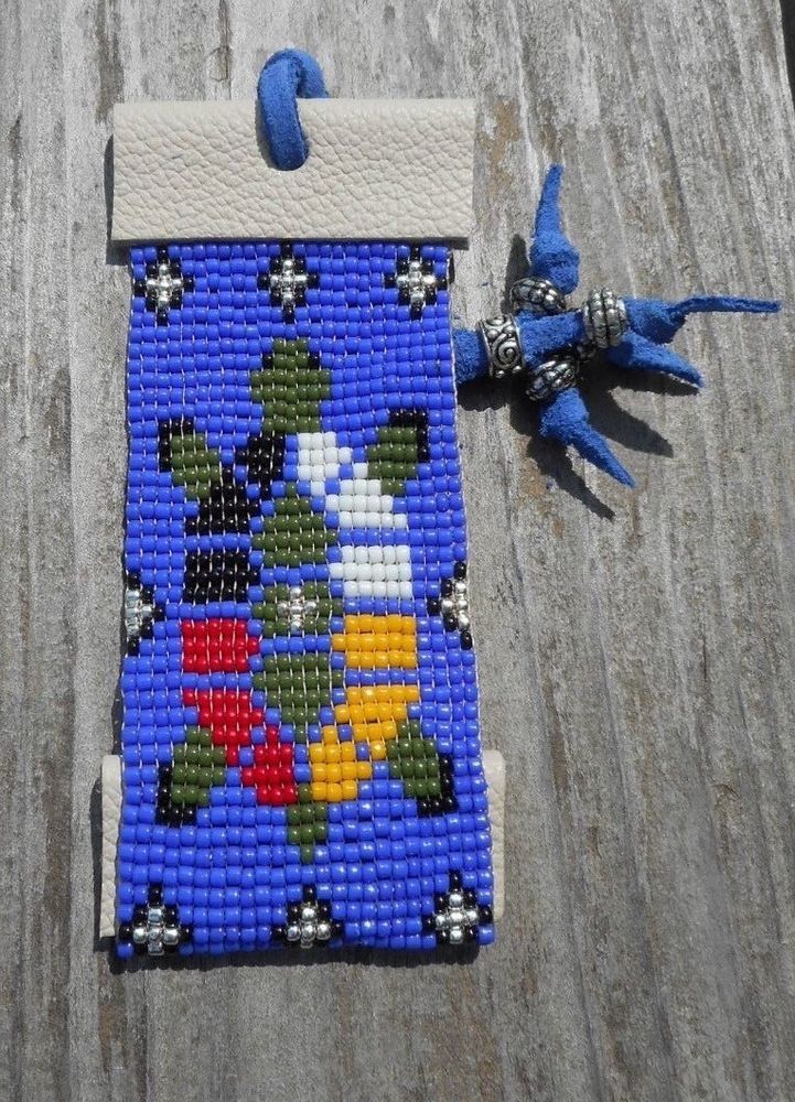 a blue beaded case with flowers on it sitting on top of a wooden table