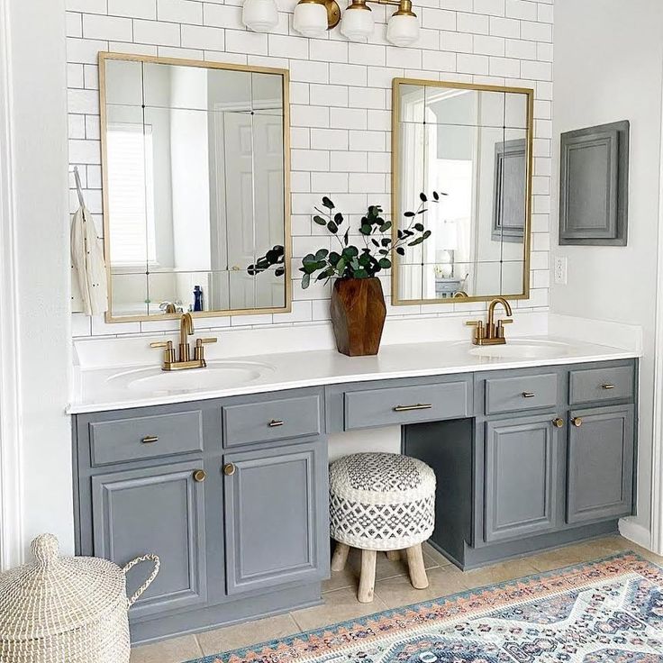 a bathroom with two sinks, mirrors and rugs on the floor in front of it