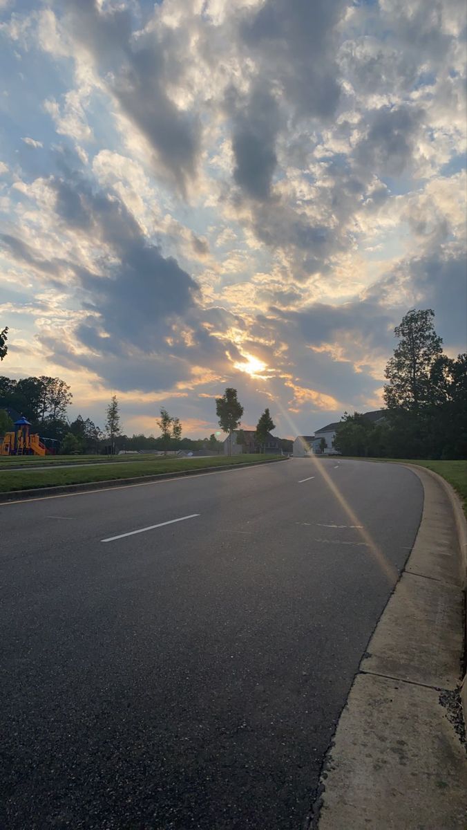 the sun is setting on an empty street