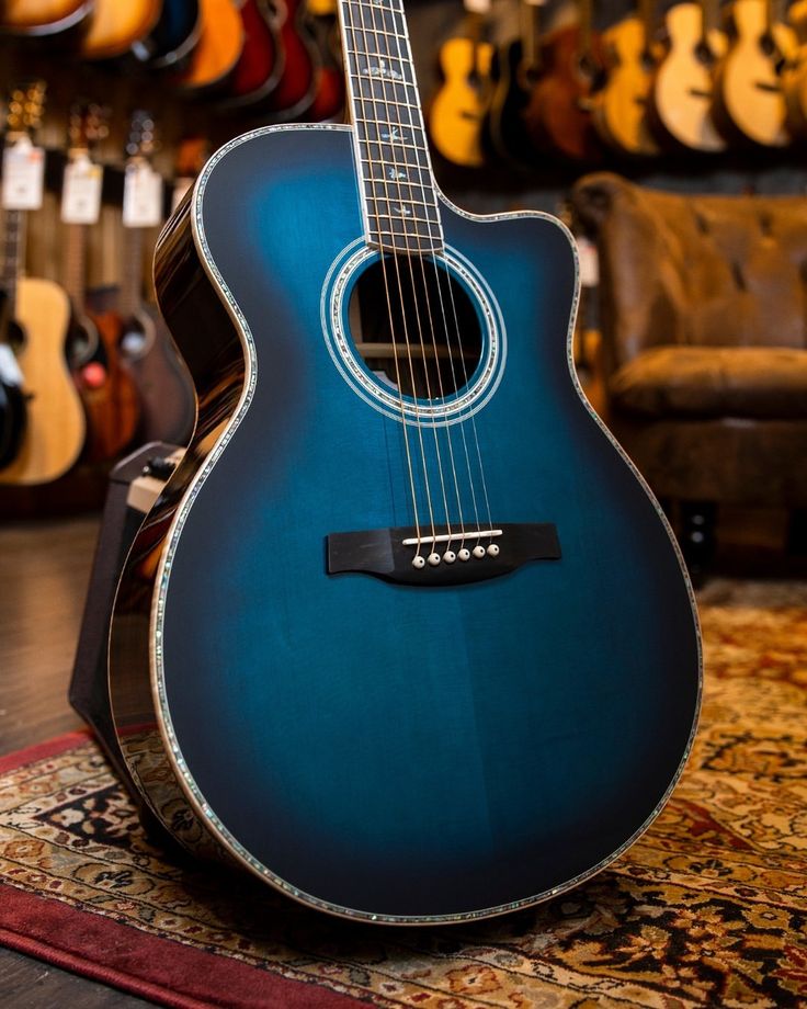 a blue acoustic guitar sitting on top of a rug