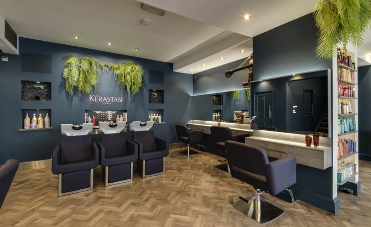 the interior of a salon with blue walls and chairs