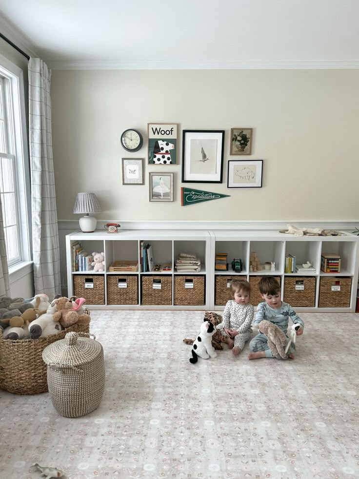 two children sitting on the floor with stuffed animals