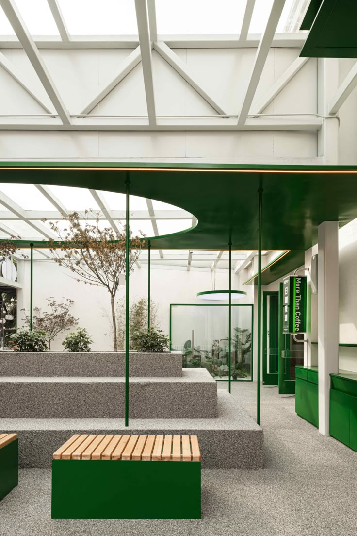 the inside of a building with green and white walls, concrete steps and benches in front of them