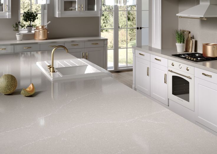 a large kitchen with white cabinets and marble counter tops, along with an island in the middle