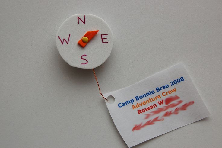 a white clock with the words camp bonnie bratt 2003 and an orange arrow on it