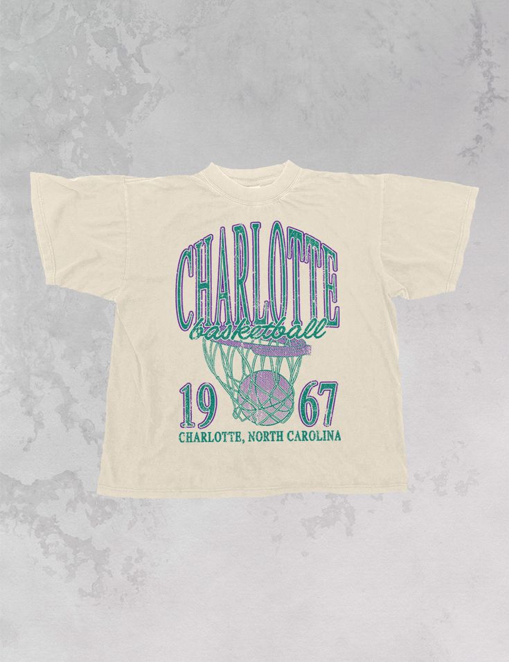 Show the love for your favorite team in this Charlotte, NC Basketball oversized tshirt that is inspired by vintage 90s N B A tshirts! - Features Charlotte Basketball across the top with a basketball hoop and 1967 with Charlotte, North Carolina underneath all in a purple and teal ink - Screen print transfer that is heat pressed onto each tshirt- Tshirt is a super soft vintage wash that gets softer after each wash- Oversized fit- Sizing translation: XS/S - L , S/M - XL , L/XL - 2XL , 2XL/3XL - 3XL * colors may vary slightly due to screens and filters * Vintage Sports Shirt, Basketball Apparel, Charlotte Basketball, Basketball Logo, 90s Sports, Merch Design, Screen Print Transfer, Purple And Teal, Print Transfer