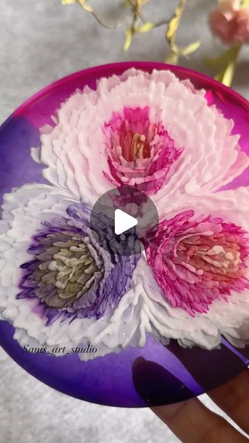 a person holding a purple plate with flowers painted on it