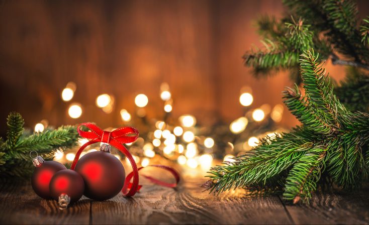 christmas decorations on wooden table with lights in the background stock photo