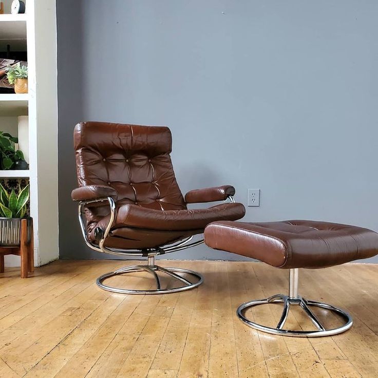 a brown leather chair and ottoman in a living room